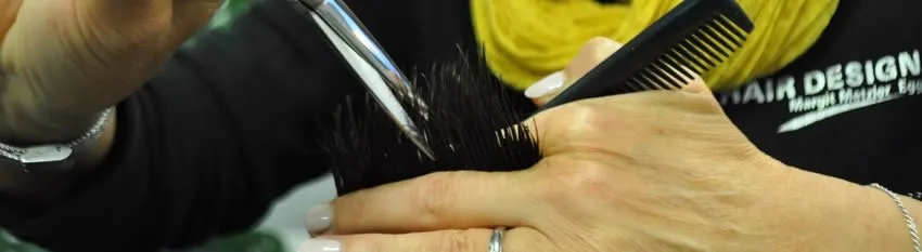 Haarschnitt im Salon, auf dem Shirt ist die Wortmarke Hair Design zu sehen