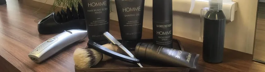 Herrenpflegeprodukte und Friseurwerkzeuge an einem Platz im Salon